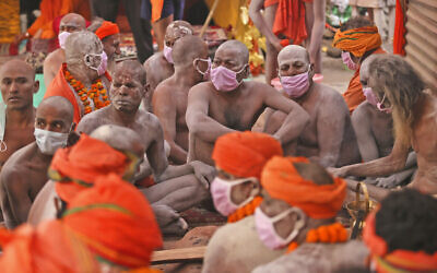 Naga Sadhu, naked Hindu holy men, wait for the start of a procession towards the river Ganges for Shahi Snan (Royal Bath) during Kumbh Mela, in Haridwar in the Indian state of Uttarakhand, Monday, April 12, 2021. As states across India are declaring some version of a lockdown to battle rising COVID-19 cases in a nationwide second-wave, thousands of pilgrims are gathering on the banks of the river Ganges for the Hindu festival. The faithful believe that a dip in the waters of the Ganges will absolve them of their sins and deliver them from the cycle of birth and death. (AP Photo/Karma Sonam)