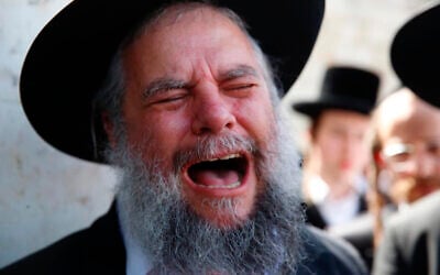 A man weeps at the funeral of Rabbi Eliezer Goldberg, who died during Lag BaOmer celebrations at Mt. Meron in northern Israel, in Jerusalem on Friday, April 30, 2021.(AP Photo/Ariel Schalit)