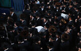 Ultra-Orthodox men carry the bodies of Moshe Englard, 14, and his brother, Yehoshua, 9, who died during Lag B'Omer celebrations at Mt. Meron in northern Israel, in Jerusalem on Friday, April 30, 2021. (AP Photo/Ariel Schalit)