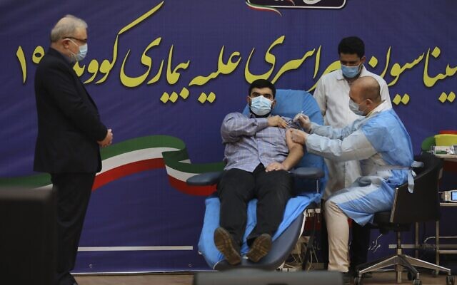 In this February 9, 2021, photo, Parsa Namaki, center, son of Health Minister Saeed Namaki, left, is injected with the Russian Sputnik V coronavirus vaccine in a ceremony at Imam Khomeini hospital in Tehran, Iran. (AP Photo/Vahid Salemi, File)