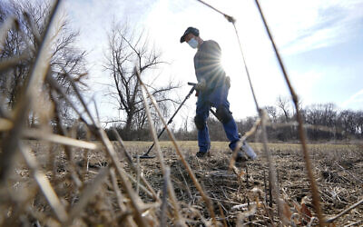 Amateur historian Jim Bailey uses a metal detector to scan for Colonial-era artifacts in a field, March 11, 2021, in Warwick (AP Photo/Steven Senne)