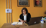Diana Moukalled, a Lebanese journalist who closely follows social media checks the Clubhouse application, at her office in Beirut, Lebanon, April 7, 2021 (AP Photo/Hussein Malla)