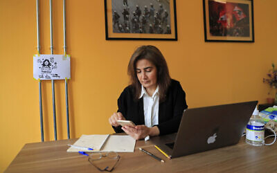 Diana Moukalled, a Lebanese journalist who closely follows social media checks the Clubhouse application, at her office in Beirut, Lebanon, April 7, 2021 (AP Photo/Hussein Malla)