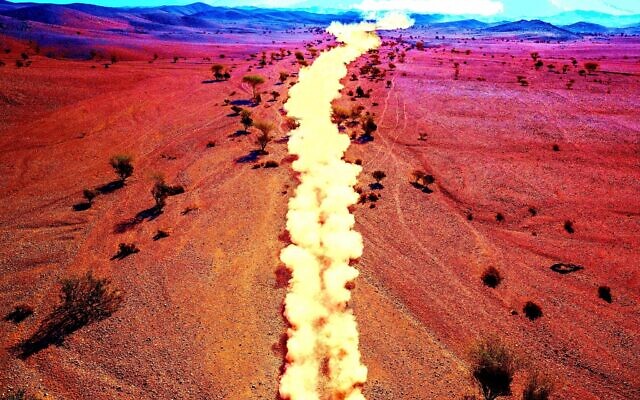 A color-adjusted photo of a race car kicking up a trail of dust during stage two of the Dakar Rally between Al Wajh and Neom, Saudi Arabia, on Monday, January 6, 2020. (Photo: AP/Bernat Armangue; Illustration: Joshua Davidovich/Times of Israel)