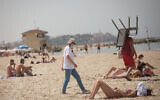 Israelis enjoy the beach on a hot spring day, in Tel Aviv, April 6, 2021.(Miriam Alster/FLASH90)