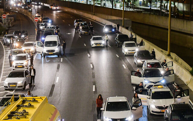 People stand still as one minutre siren sounded across Israel, marking Memorial Day which commemorates the fallen Israeli soldiers and victims of terror in Ayalon highway, Tel Aviv, April 13, 2021. (Avshalom Sassoni/Flash90) People stand still as one minutre siren sounded across Israel, marking Memorial Day which commemorates the fallen Israeli soldiers and victims of terror in Ayalon highway, Tel Aviv, April 13, 2021. (Avshalom Sassoni/Flash90)