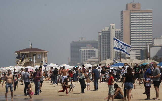 Israelis enjoy the Independence Day flyover at the Tel Aviv beach on April 15, 2021. (Miriam Alster/Flash90)
