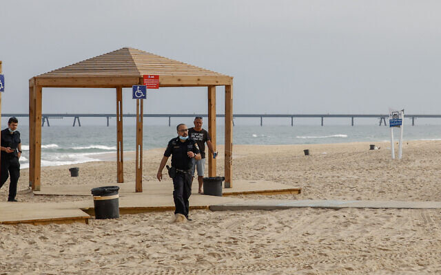 Israeli police officers walk on Zikim Beach close to the Gaza border after it was closed to visitors, on April 24, 2021. (Flash90) Israeli police officers walk on Zikim Beach close to the Gaza border after it was closed to visitors, on April 24, 2021. (Flash90)