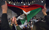 Palestinians gather and wave a Palestinian flag at Damascus Gate in Jerusalem's Old City, during the holy Muslim month of Ramadan, April 26, 2021. (Olivier Fitoussi/Flash90)
