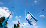 Israeli medical staff cheer an Israeli airforce aerobatic team as they fly over Shaarei Tsedek hospital in Jerusalem on Israel's 72nd Inependence Day, April 29, 2020. (Olivier Fitoussi/Flash90)