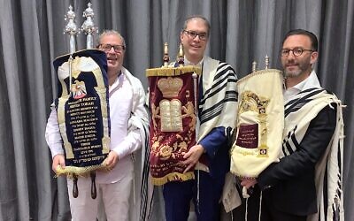 Cantor and Jewish Community of the Emirates (JCE) Co-founder Alex Peterfreund (right), Chief Rabbi of the UAE Yehuda Sarna (center) and JCE President Ross Kriel hold Torah scrolls at V Hotel Dubai, where the community's Passover services and meals were held, on April 4, 2021 (Miriam Herschlag/TOI)