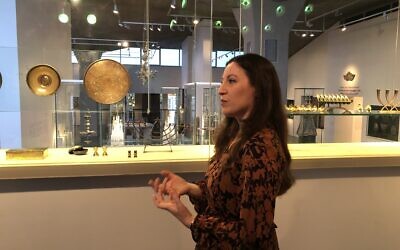 Israel Museum curator Sharon Weiser-Ferguson with items from the Jewish Art and Life wing, some donated by his parents in memory of Yadin Tanenbaum, who fell in the Yom Kippur War (Jessica Steinberg/Times of Israel)