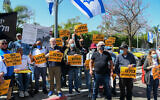Protesters hold signs reading, 'We are all Itzik Saidyan,' outside the Defense Ministry's Rehabilitation Department in Petah Tikva, April 14, 2021. (Flash90)