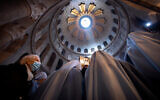 A woman wearing a face mask attends Easter Sunday Mass led by Latin Patriarch of Jerusalem Pierbattista Pizzaballa at the Church of the Holy Sepulchre in the Old City of Jerusalem, April 4, 2021. (AP Photo/Oded Balilty)