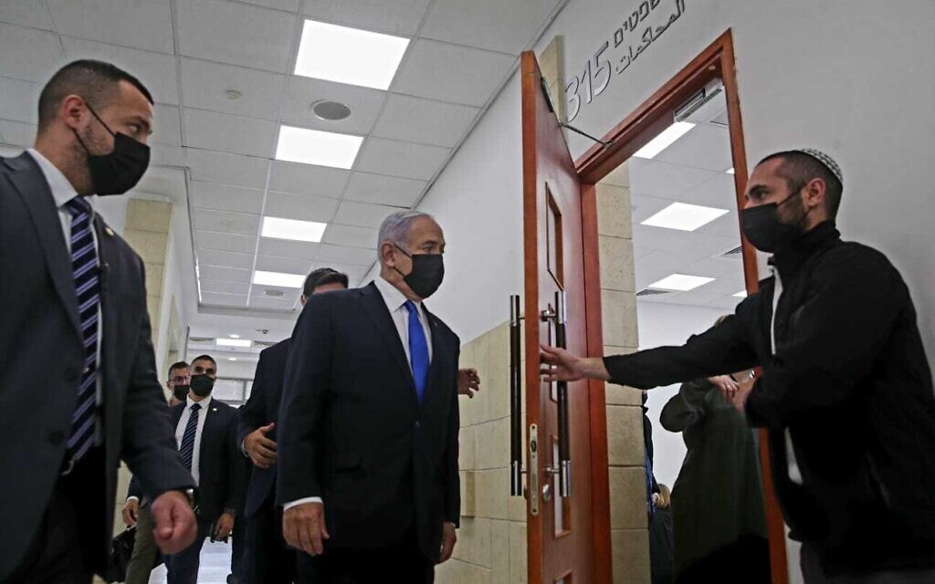 Prime Minister Benjamin Netanyahu, center, enters a courtroom at the Jerusalem District Court for a hearing in his corruption trial, April 5, 2021. (Oren Ben Hakoon/Pool)