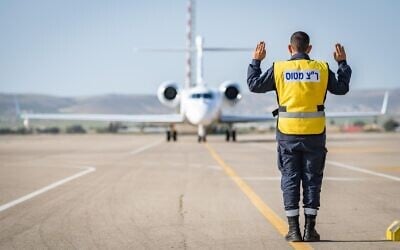 An air traffic controller directs an Oron spy aircraft down a runway at the Nevatim air base in southern Israel on April 4, 2021. (Israel Defense Forces)
