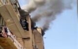 Screen capture from video of a boy, 12, leaning out of window during a fire at an apartment in Rishon Lezion, April  28, 2021. (Channel 12 News)