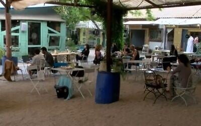People sit outside at a cafe in the town of Pardes Hanna, April 27, 2020 (Screen grab/Walla)