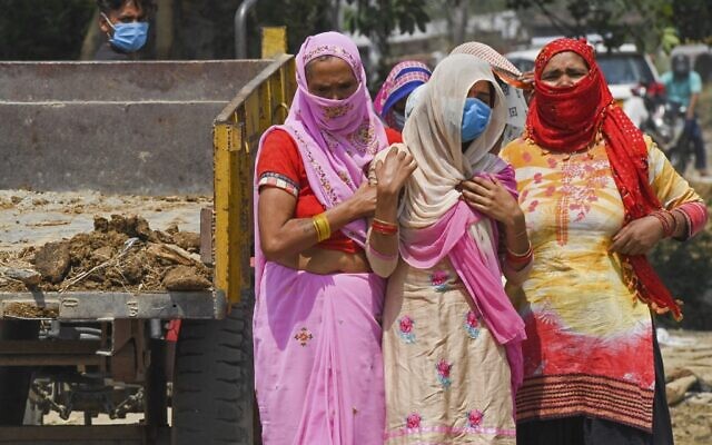 In this picture taken on May 5, 2021, relatives grieve as they arrive for the cremation of their loved one who died due to the COVID-19 coronavirus at a crematorium in Moradabad (Prakash SINGH / AFP) In this picture taken on May 5, 2021, relatives grieve as they arrive for the cremation of their loved one who died due to the COVID-19 coronavirus at a crematorium in Moradabad (Prakash SINGH / AFP)