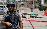 An Israeli soldier stands guard as the bodies of two Palestinian attackers, who opened fire and were killed by Israeli security forces, lie on the ground in front of the IDF military base of Salem near the West Bank town of Jenin, on May 7, 2021. (Photo by Jack GUEZ / AFP)
