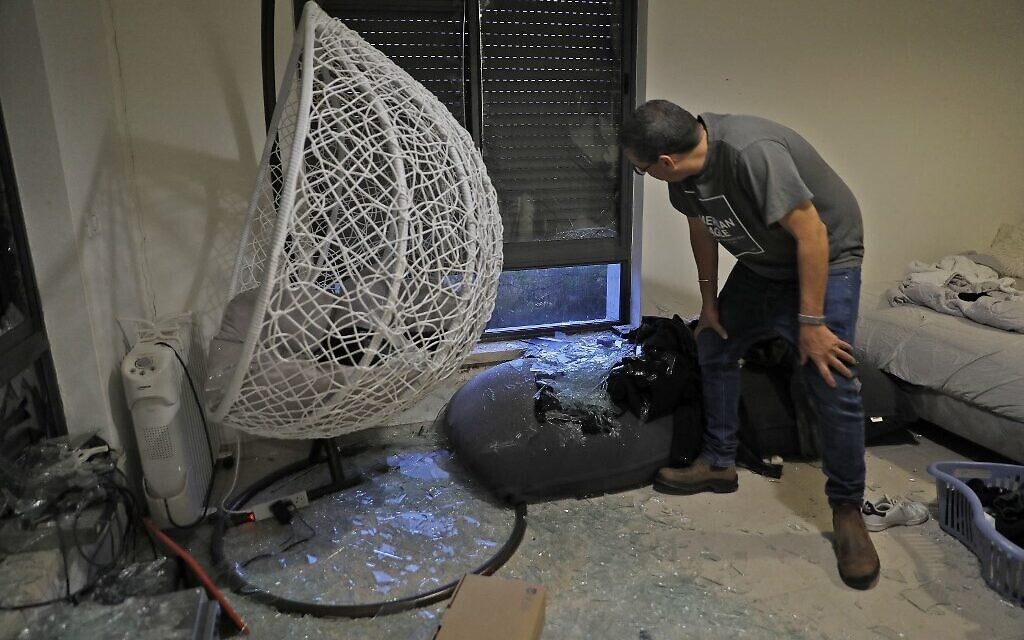 An Israeli man checks debris at a house on the outskirts of Jerusalem where a rocket fired from the Gaza Strip, controlled by the Palestinian terror group Hamas, fell on May 10, 2021. (Photo by Gil COHEN-MAGEN / AFP)