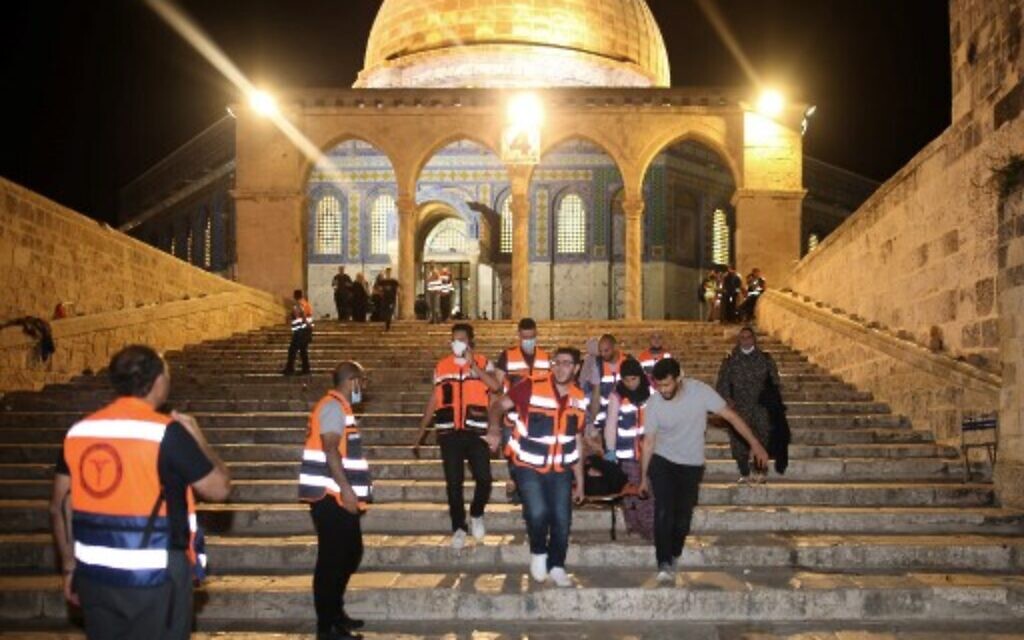 Palestinian medics evacuate a wounded person during clashes between Israeli security forces and Palestinian protestors in Jerusalem's Temple Mount compound on May 10, 2021. (Ahmad Gharabli/AFP)