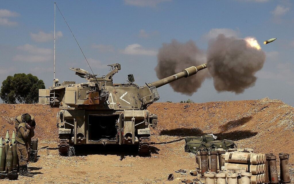 Israeli soldiers fire toward the Gaza Strip from their position near the southern Israeli city of Sderot on May 13, 2021 (Menahem KAHANA / AFP)