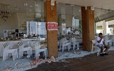 An Israeli man sits at a restaurant that was attacked the previous night in Israel's Mediterranean city of Bat Yam on May 13, 2021 (Gil COHEN-MAGEN / AFP)