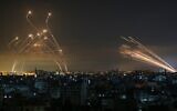 Rockets from Gaza, on right, are seen in the night sky fired towards Israel from Beit Lahia in the northern Gaza Strip on May 14, 2021, while Iron Dome interceptor missiles, on left, rise to meet them. (Anas Baba/AFP)