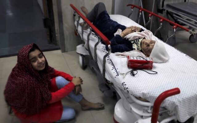 A Palestinian girl sits on the floor next to her wounded grandmother at Al-Shifa Hospital, after an Israeli air strike struck al-Shati Refugee Camp in Gaza City early on May 15, 2021.(Photo by MAHMUD HAMS / AFP) A Palestinian girl sits on the floor next to her wounded grandmother at Al-Shifa Hospital, after an Israeli air strike struck al-Shati Refugee Camp in Gaza City early on May 15, 2021.(Photo by MAHMUD HAMS / AFP)