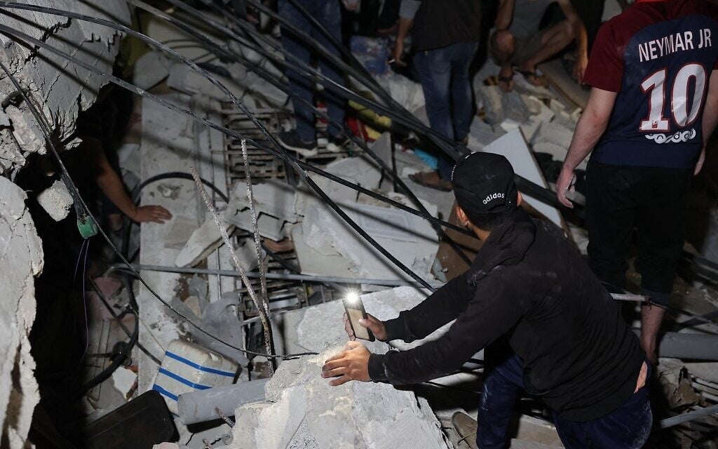 Palestinian firefighters search for survivors and bodies under the rubble after an intensive bombardment of Gaza City following rocket fire, May 16, 2021 (MOHAMMED ABED / AFP)