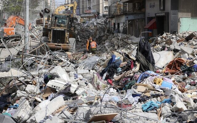 An excavator clears the rubble of a destroyed building in Gaza City's Rimal residential district on May 16, 2021. (Mahmud Hams / AFP)
