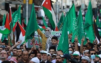 Demonstrators lift flags during a pro-Palestinian protest in the Jordanian capital Amman on May 16, 2021. (Khalil MAZRAAWI / AFP)