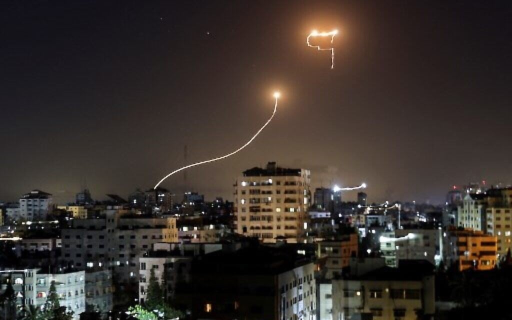 A streak of light appears as Israel's Iron Dome anti-missile system intercepts rockets launched from the Gaza Strip, on May 16, 2021.  (Photo by MAHMUD HAMS / AFP)