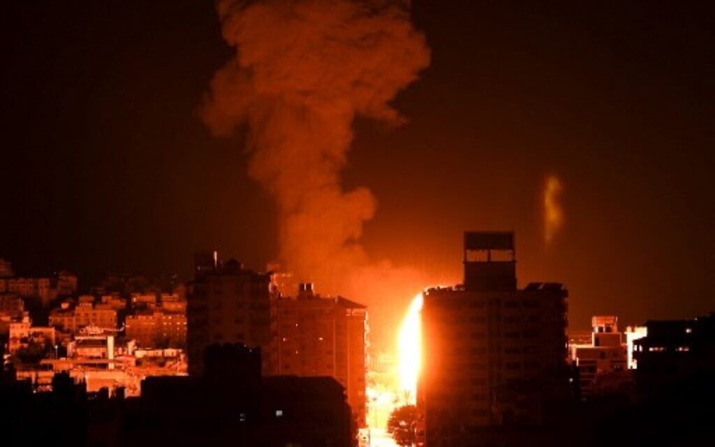 Fire and smoke rise above buildings in Gaza City as Israeli warplanes carry out strikes, early on May 17, 2021. (Photo by MAHMUD HAMS / AFP)
