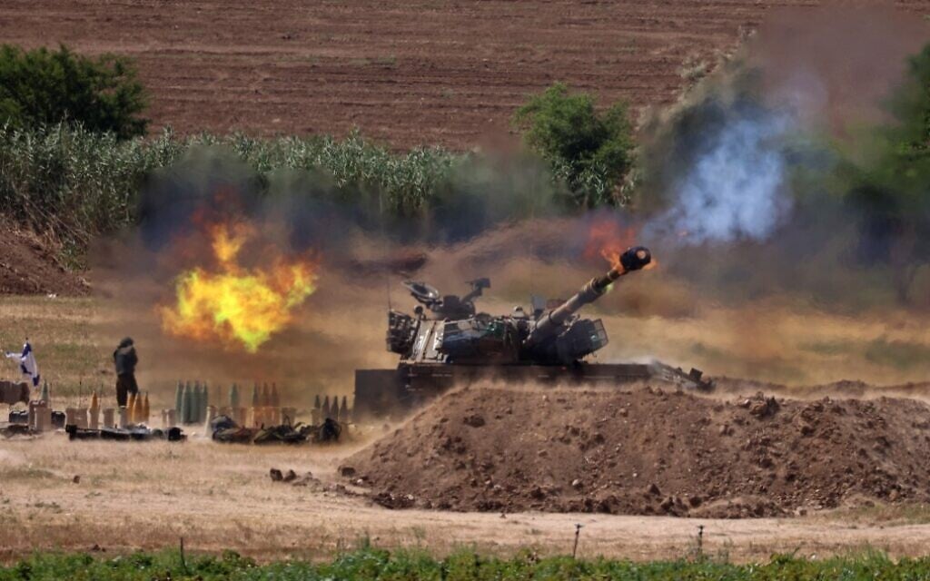 Israeli soldiers fire an artillery piece toward the Gaza Strip from their position along the border with the Hamas-ruled Palestinian enclave, on May 17, 2021. (Emmanuel Dunand/AFP)