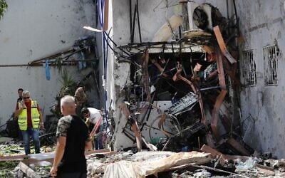 Israeli residents and rescue teams are pictured outside a building hit by a rocket launched from the Gaza Strip, in the southern city of Ashdod, on May 17, 2021. (Ahmad GHARABLI / AFP)