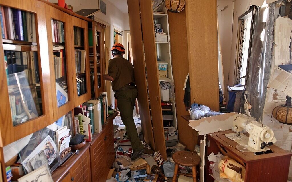 Rescue forces inspect the damage inside an apartment that was hit by a rocket launched from the Gaza Strip on May 17, 2021 in the southern city of Ashdod (Ahmad GHARABLI / AFP)