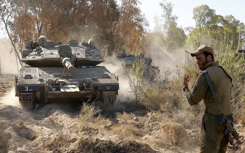Israeli soldiers direct Merkava tanks to firing positions during shelling toward the Gaza Strip, along the border with the Palestinian enclave on May 19, 2021 (JACK GUEZ / AFP)