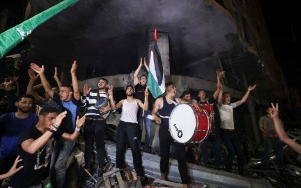 Palestinians celebrate in the streets following a ceasefire between Israel and Hamas, in Gaza City on May 21, 2021.  (Photo by MAHMUD HAMS / AFP)
