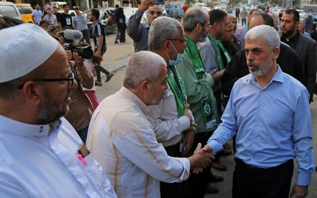 Yahya Sinwar (R), leader of the Palestinian Hamas terror group, is greeted by supporters in Gaza City on May 22, 2021, as he arrives to pay condolences to top Hamas commander Bassem Issa who was killed along others in Israeli airstrikes. (Hatem RAWAGH / AFP) Yahya Sinwar (R), leader of the Palestinian Hamas terror group, is greeted by supporters in Gaza City on May 22, 2021, as he arrives to pay condolences to top Hamas commander Bassem Issa who was killed along others in Israeli airstrikes. (Hatem RAWAGH / AFP)
