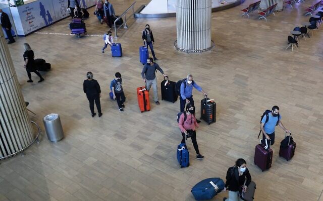 Israelis and vaccinated tourists wearing masks for COVID-19 protection arrive to Israel's Ben Gurion Airport near Tel Aviv on May 23, 2021, after a partial re-opening of the border to inoculated tourists from 14 countries. (JACK GUEZ / AFP)