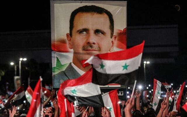 Syrians wave national flags and carry a large portrait of their president as they celebrate in the streets of the capital Damascus, a day after an election set to give the current President Bashar Assad a fourth term, on May 27, 2021 (LOUAI BESHARA / AFP) Syrians wave national flags and carry a large portrait of their president as they celebrate in the streets of the capital Damascus, a day after an election set to give the current President Bashar Assad a fourth term, on May 27, 2021 (LOUAI BESHARA / AFP)
