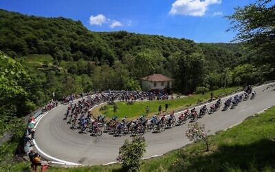 Spectators watch riders of the pack in Sovazza during the 19th stage of the Giro d'Italia 2021 cycling race on May 28, 2021. (Luca Bettini / AFP)