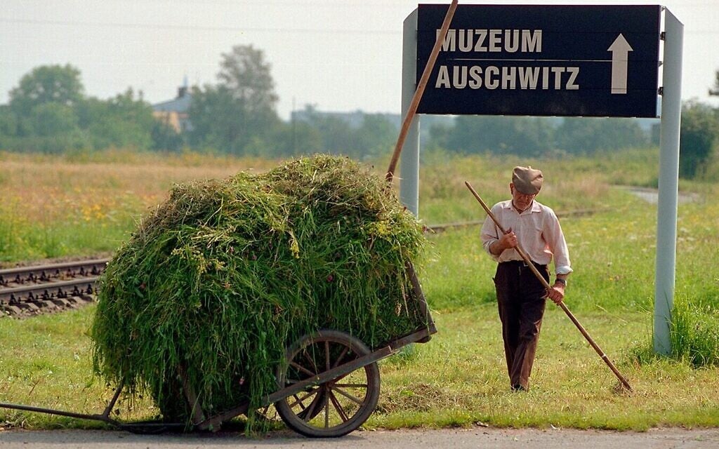 A groundskeeper working beside the train tracks that lead to Auschwitz in this still from the 1998 documentary 'The Last Day.' (Courtesy)