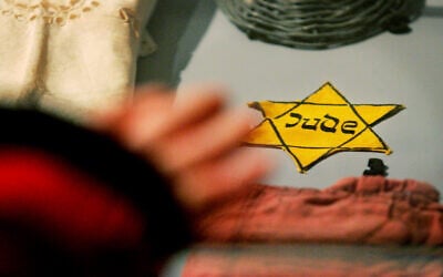 A yellow Star of David Jews were forced to wear by the Nazis, is seen with other belongings of Holocaust survivors from the Auschwitz-Birkenau concentration camp that are on display at the Yad Vashem Holocaust Memorial in Jerusalem, January 24, 2005 (AP Photo/Kevin Frayer)