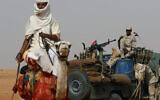 In this June 22, 2019 file photo, Gen. Mohammed Hamdan Dagalo, the deputy head of the military council sits on his vehicle surrounded by soldiers from the Rapid Support Forces unit during a military-backed tribal rally, in the East Nile province, Sudan. (AP/Hussein Malla)