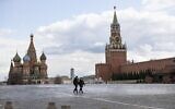 Two police officers patrol an almost empty Red Square, with St. Basil's Cathedral, center, and Spasskaya Tower in Moscow, Russia, April 20, 2020 (AP Photo/Alexander Zemlianichenko)