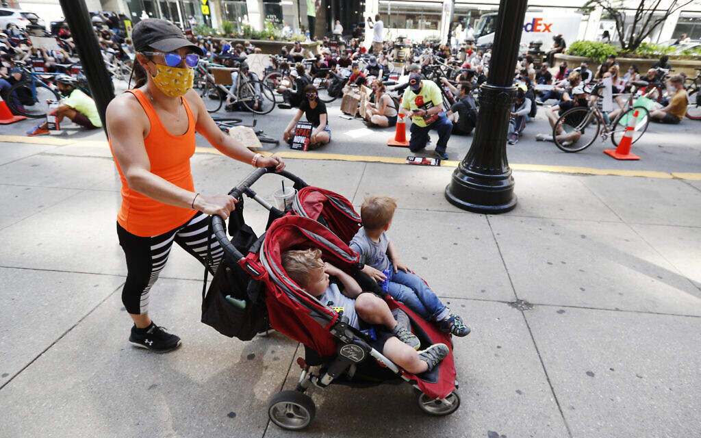 Illustrative: A woman and two children pass protesters sitting on La Salle Street in front of Chicago's City Hall, Wednesday, June 17, 2020 (AP Photo/Charles Rex Arbogast) Illustrative: A woman and two children pass protesters sitting on La Salle Street in front of Chicago's City Hall, Wednesday, June 17, 2020 (AP Photo/Charles Rex Arbogast)