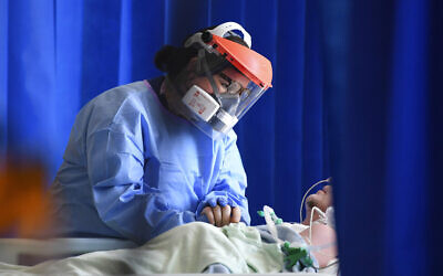 Illustrative image: a member of medical staff cares for a patient with coronavirus in the intensive care unit at the Royal Papworth Hospital in Cambridge, England. (Neil Hall/Pool via AP, File)